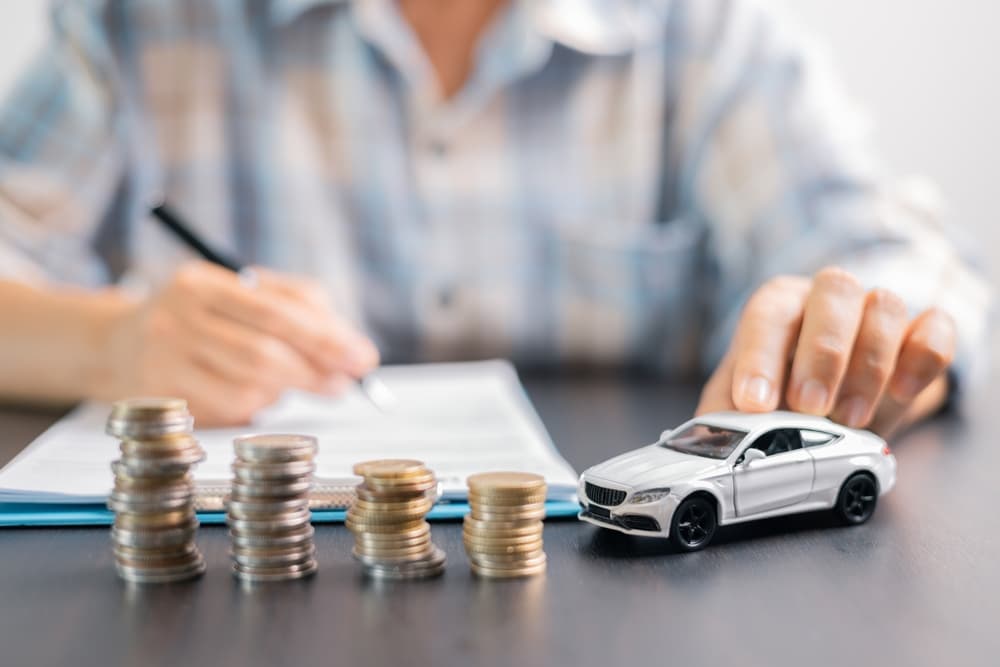 A businessman in an office planning vehicle finance and protection—covering investment, insurance, buying, selling, and securing a favorable car loan deal.