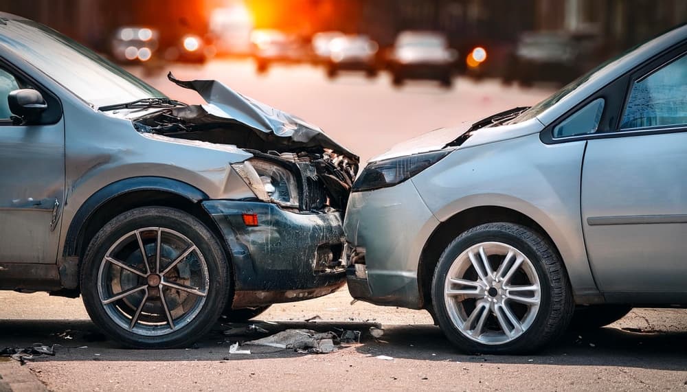 Car crash accident on the street involving damaged vehicles — representing a car insurance concept.