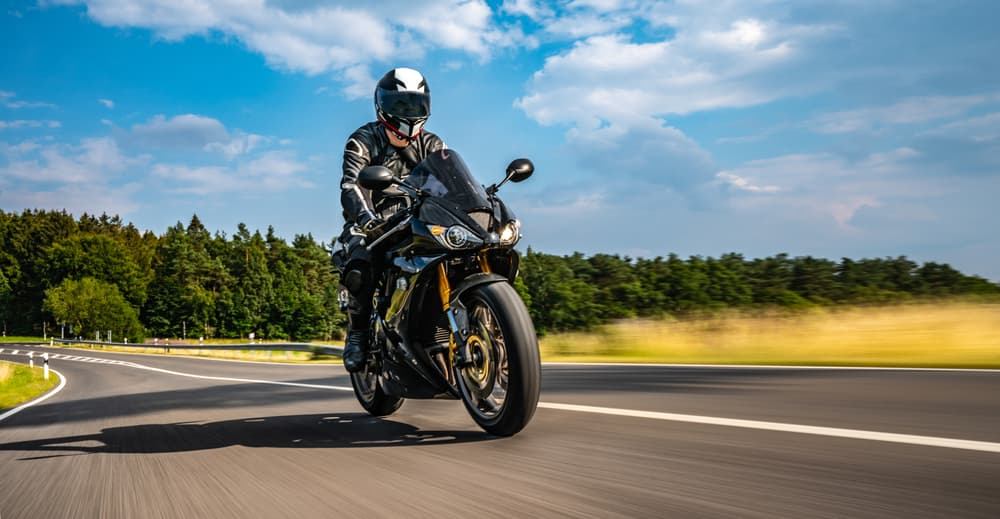 A motorbike speeds down an empty highway, capturing the excitement and freedom of a fast-paced motorcycle journey.