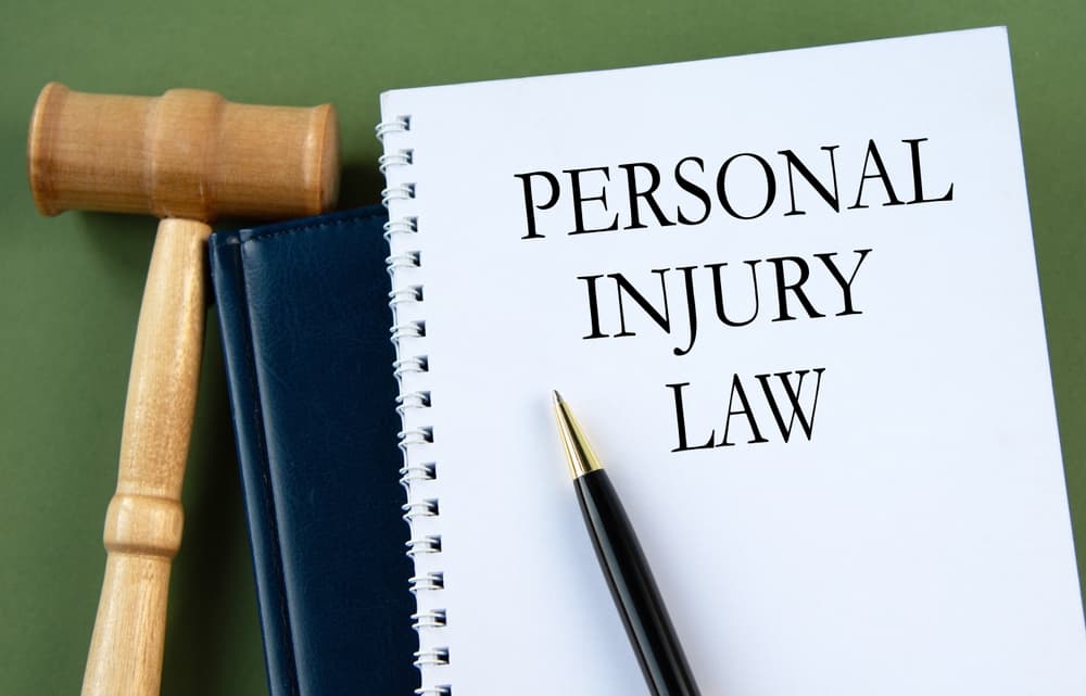 The words 'PERSONAL INJURY LAW' displayed on a white sheet alongside a judge's gavel.