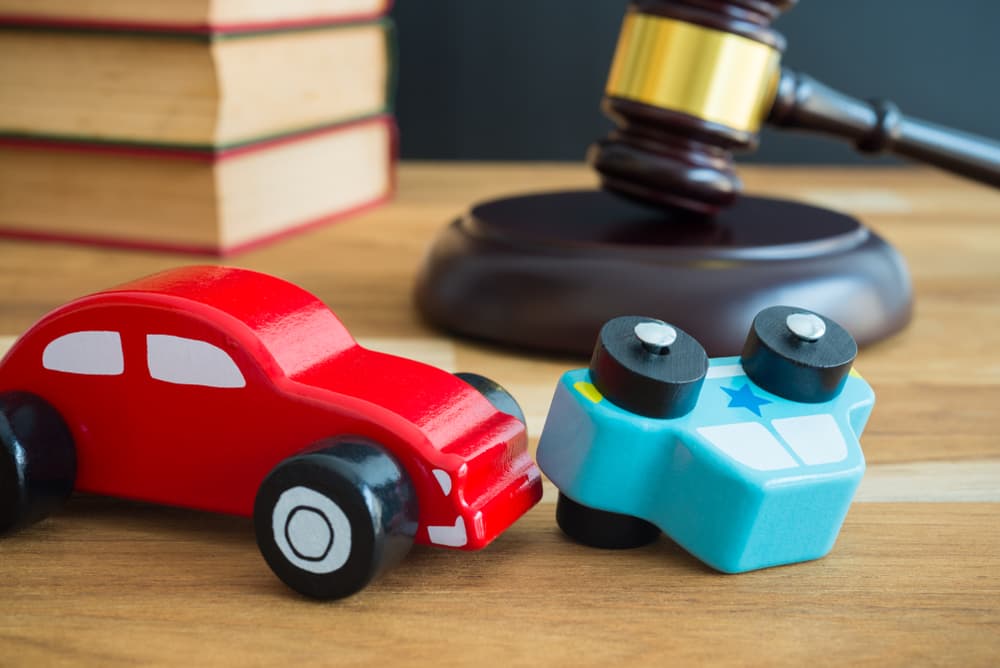 Law concept featuring a car accident, auto insurance elements, and a judge's gavel symbolizing legal proceedings.