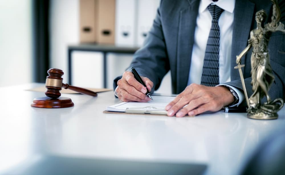 A lawyer or businessman works in an office or courtroom with a gavel and legal documents, representing legal counsel, justice, and the practice of law.
