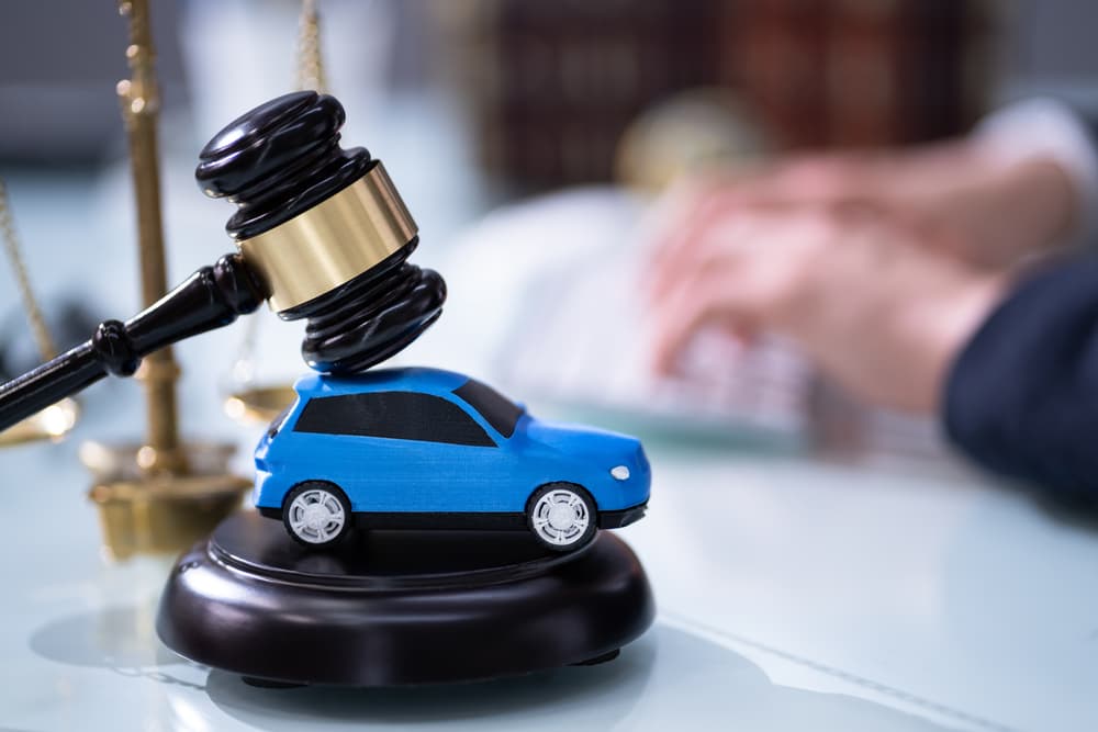 A lawyer discusses car insurance matters as a judge oversees legislation in the courtroom, symbolizing the legal process involved in vehicle-related claims and disputes.