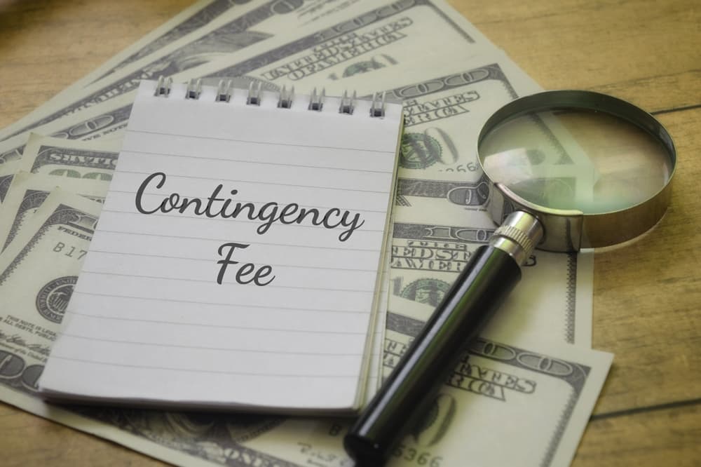 ‘Contingency Fee’ wording highlighted by a magnifying glass alongside money, representing a business concept.