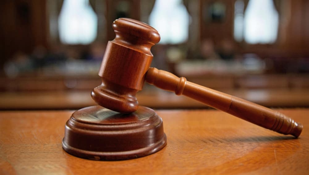 A dynamic image of a gavel striking in a courtroom captures the essence of justice and legal proceedings, making it ideal for law-related content and professional legal contexts.