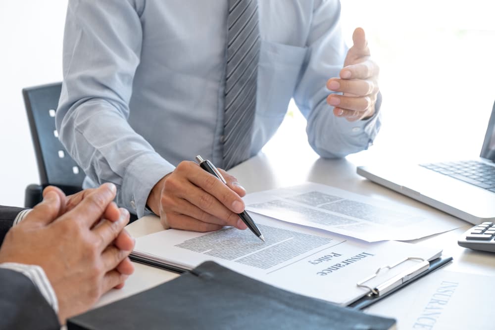 An insurance agent explains the details of an insurance policy to a customer.