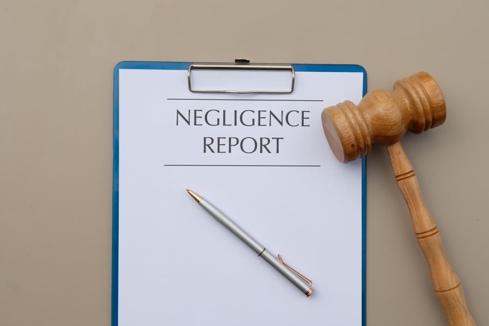 A negligence report titled is displayed on a desk alongside a gavel and pen, symbolizing legal accountability and formal documentation.