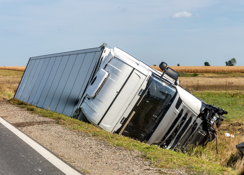 The large truck rests in a roadside ditch following the traffic accident.
