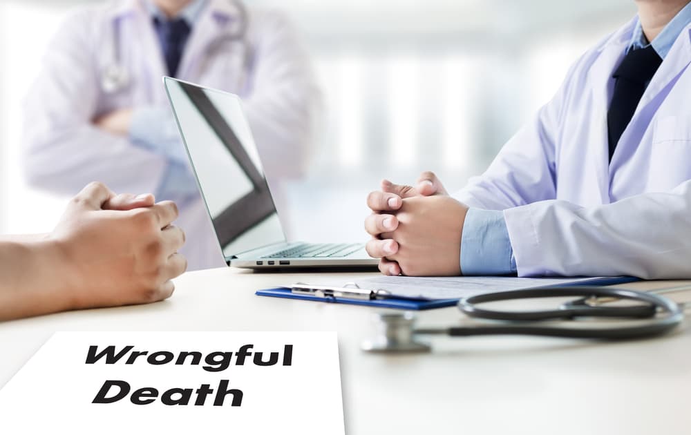 Doctor discussing wrongful death case with a patient, reviewing medical details in an office setting.