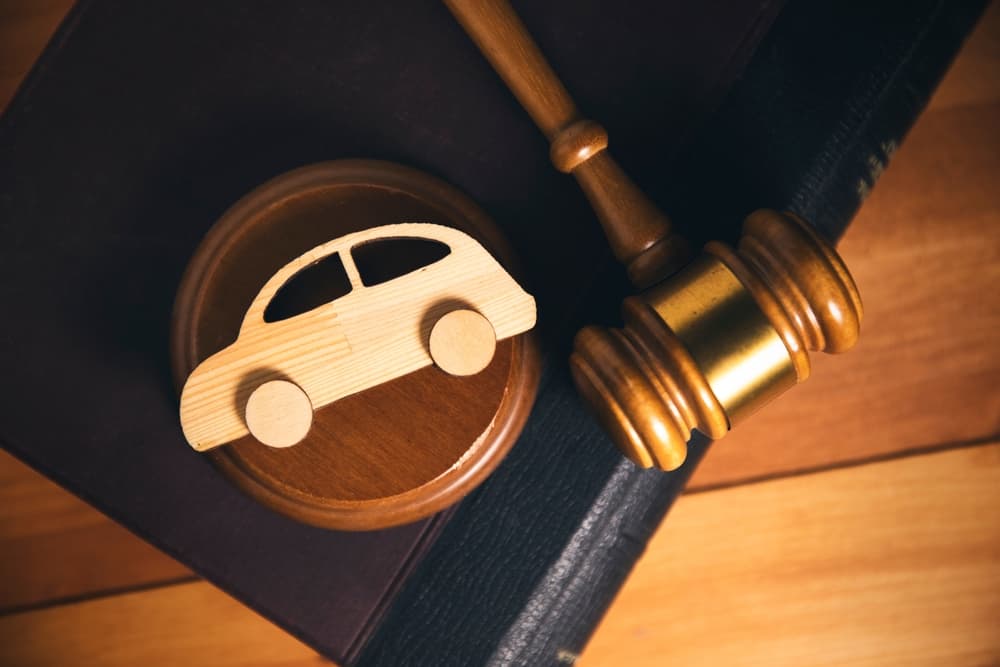 This image depicts a car accident lawsuit, showing legal professionals reviewing documents related to a vehicle collision case.