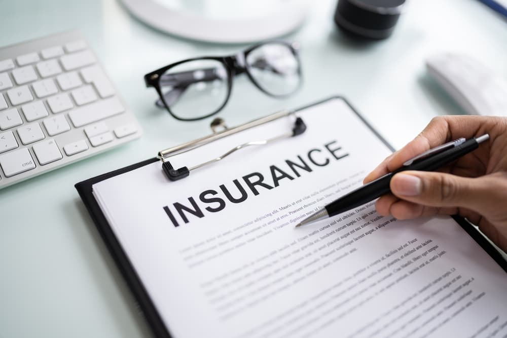 Company insurance policy document reviewed by an African American insurance agent.