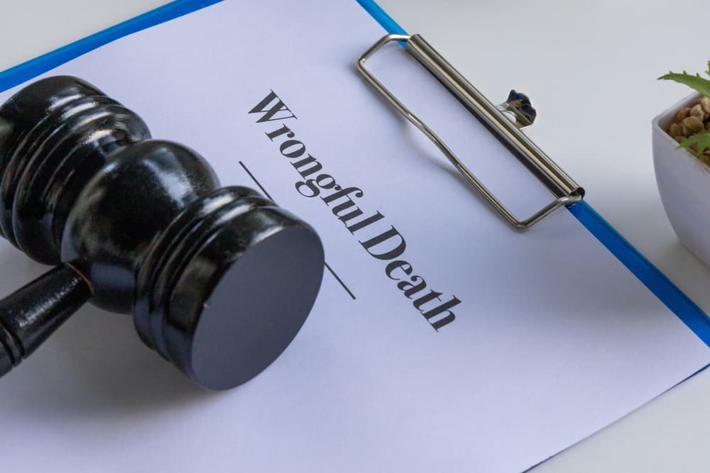 An image of a wrongful death document on a clipboard, accompanied by a judge's gavel on a desk, creating a professional and solemn atmosphere—ideal for legal or courtroom themes.