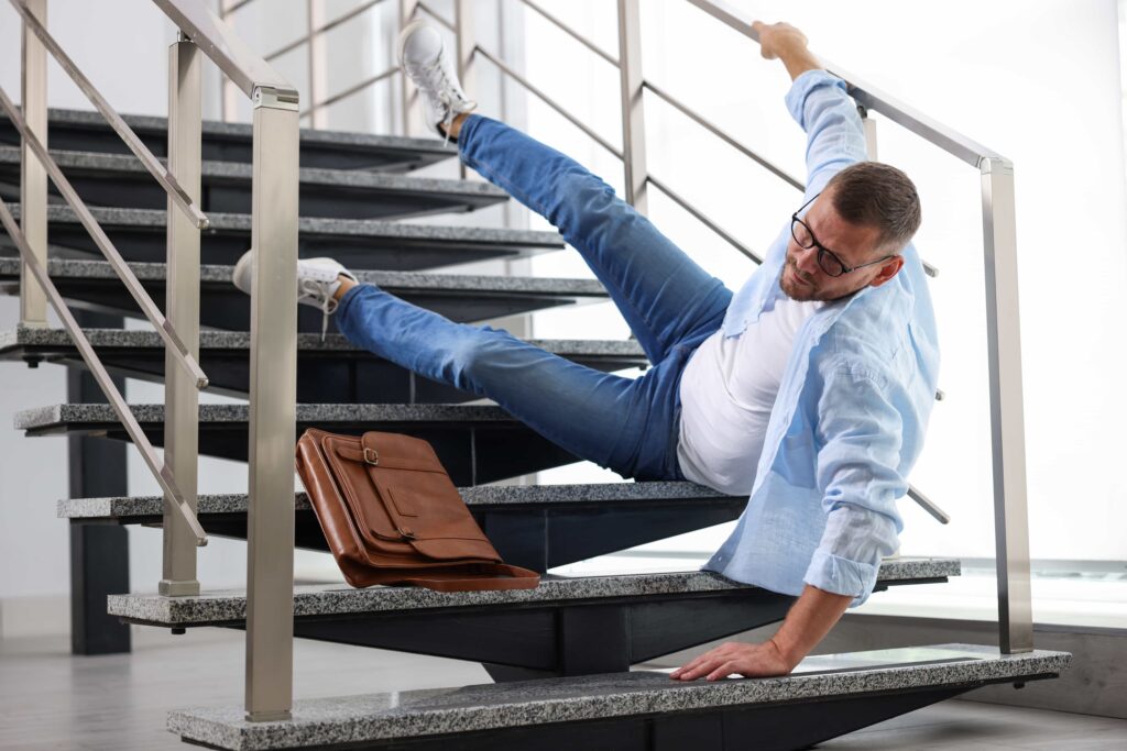 Man falling on stairs in workplace accident, highlighting slip and fall injury risk. Man falling on stairs in workplace accident, highlighting slip and fall injury risk.