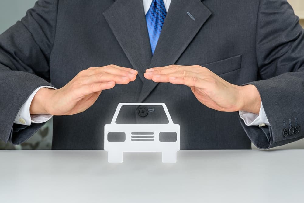 Comprehensive vehicle insurance and protection concept. A man shields a car, symbolizing the importance of insurance coverage, accident protection, and vehicle safety for personal or commercial use.