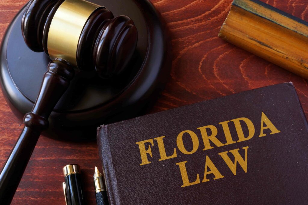Florida law book with judge’s gavel on wooden desk representing legal system and state laws.