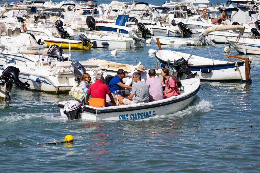 riding in a small motorboat surrounded by docked boats in a busy marina.