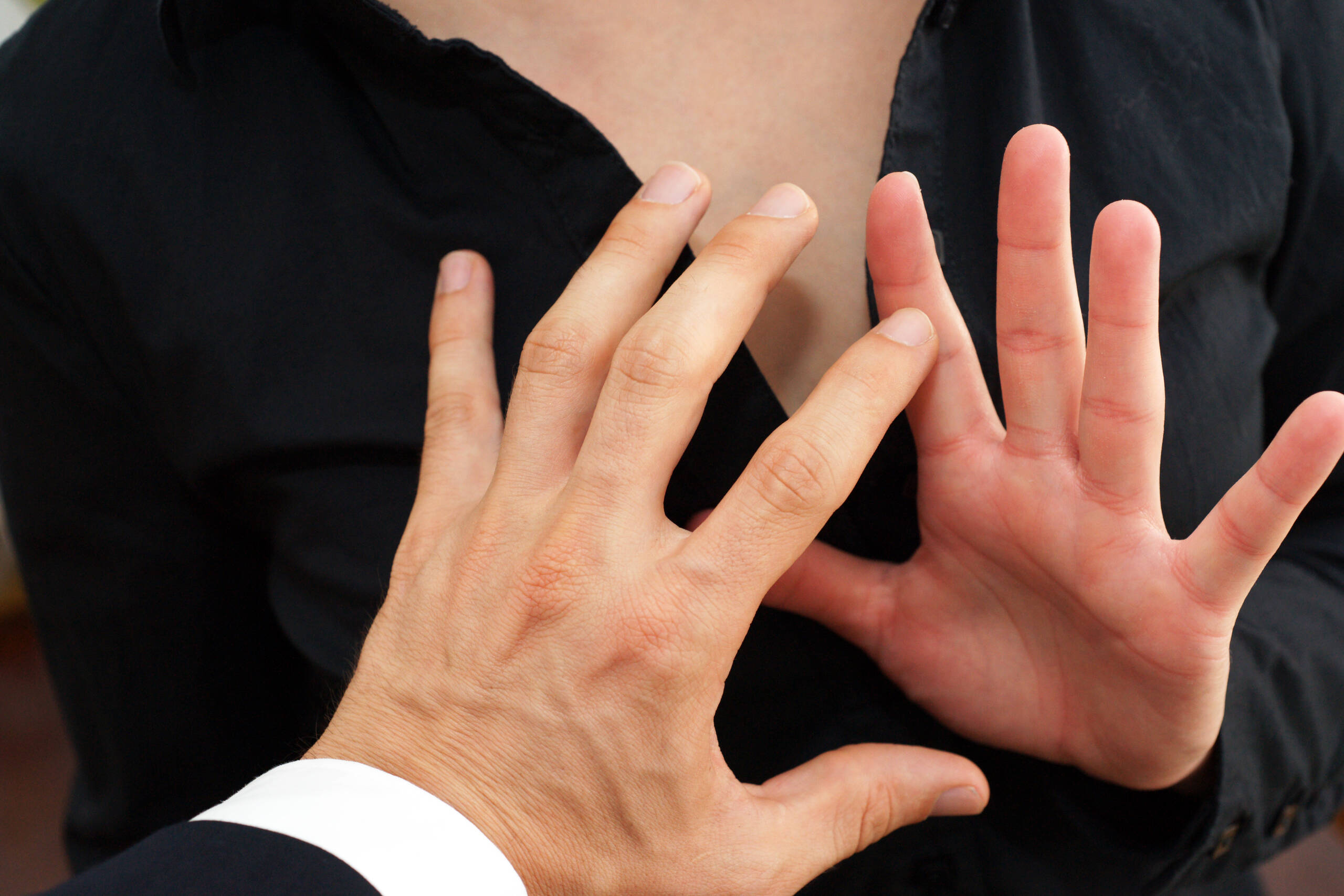 Individual raising hands defensively to stop unwanted physical contact, illustrating sexual abuse and victim protection under Florida law.