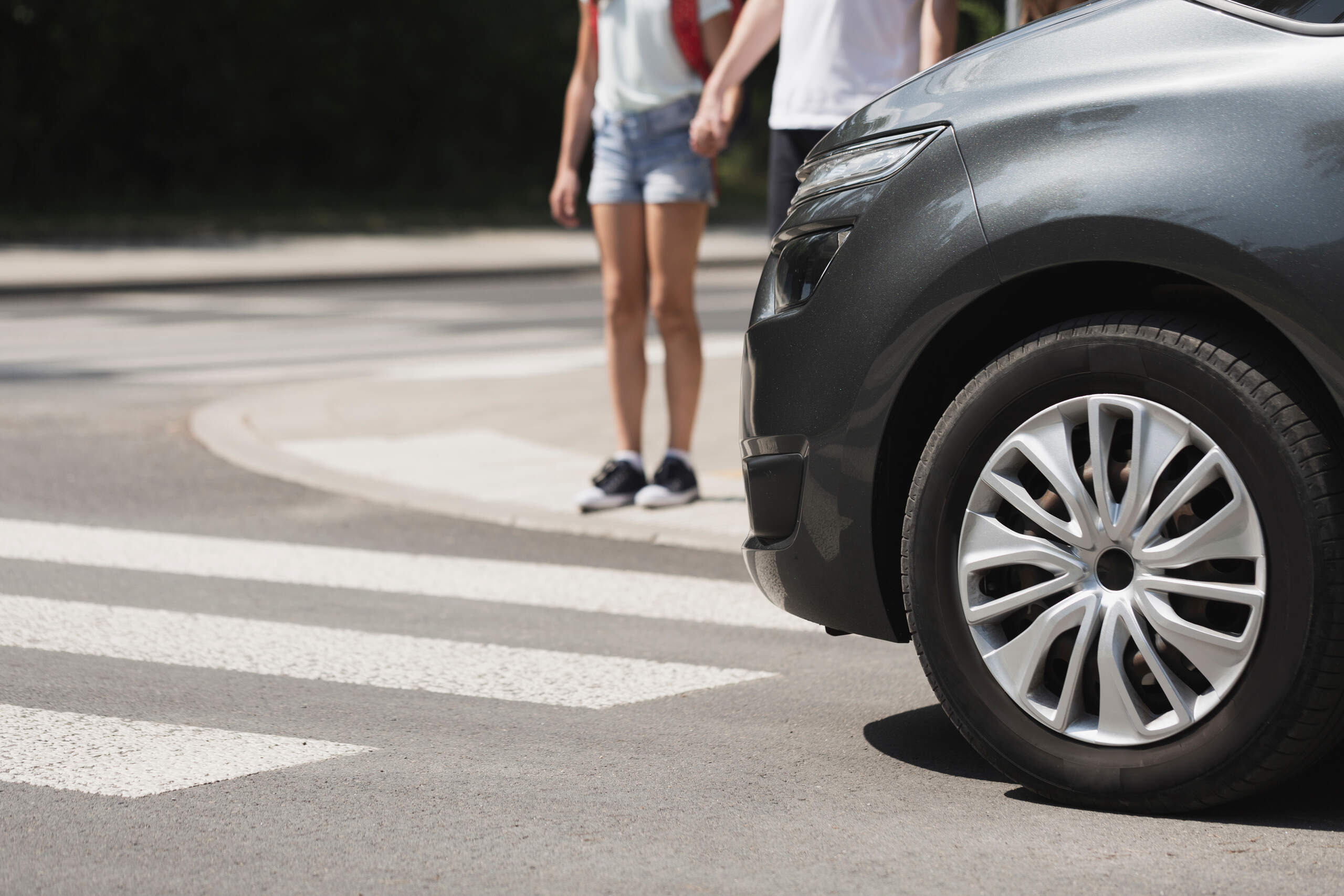 Vehicle stopped at a crosswalk with pedestrians nearby, representing a Florida pedestrian accident and injury risk