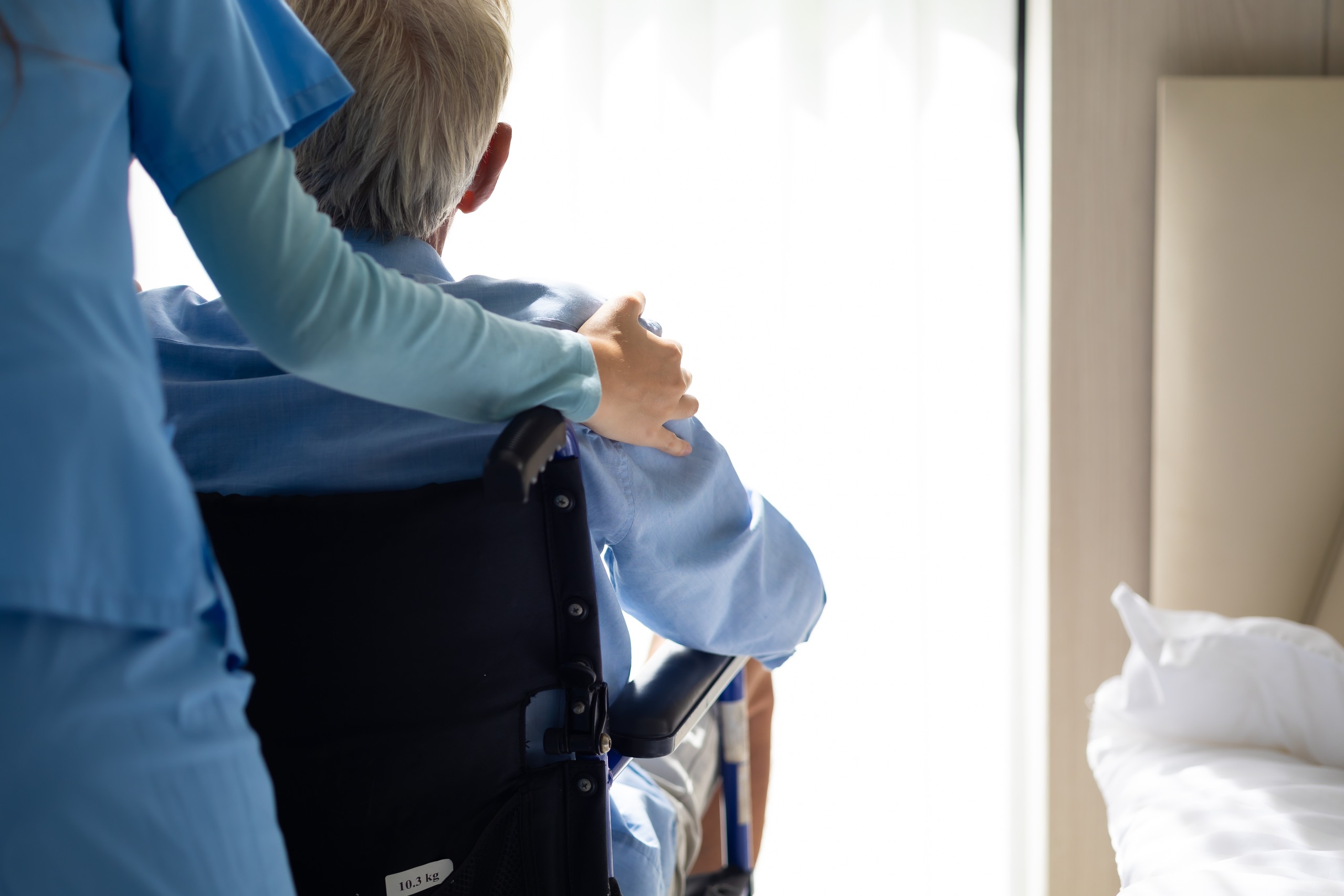 Caregiver pushing an elderly resident in a wheelchair, highlighting potential nursing home neglect or abuse in Florida.