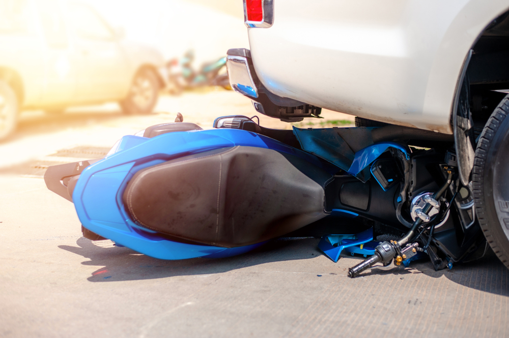 Motorcycle knocked down on a Boca Raton road next to an SUV illustrating the type of dooring motorcycle accident where a Florida rider may have legal rights to compensation
