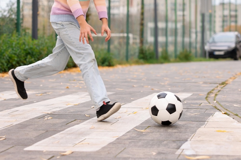 Child running across a crosswalk near a parking area representing the risk of pedestrian accidents in Boca Raton handled by Frankl Kominsky Injury Lawyers