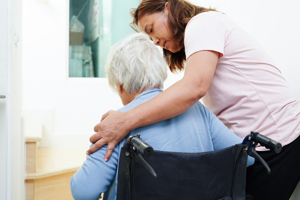 Caregiver assisting an injured person in a wheelchair after a brain injury in Boca Raton